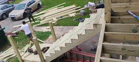 Crew framing new wooden deck stairs