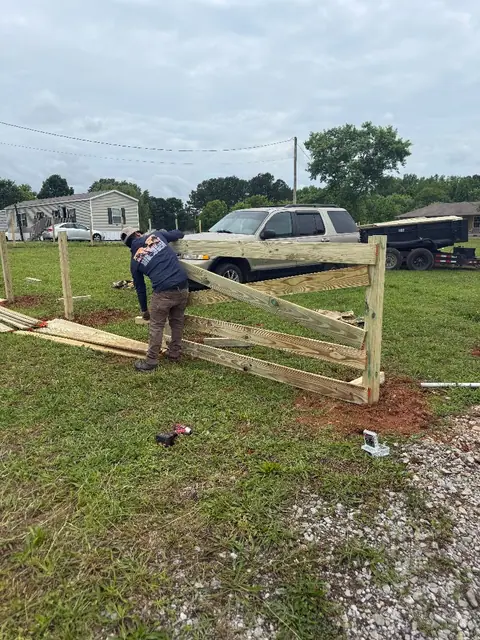 Crew installing a wood ranch-rail fence