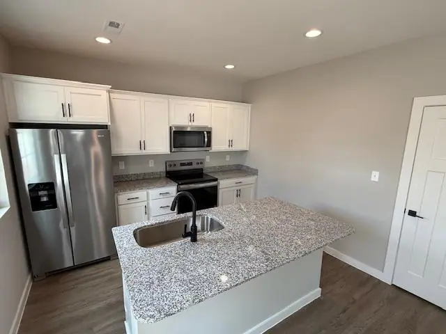 Finished white kitchen remodel with island and dark wood floors