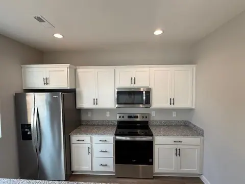 Finished white kitchen with the range and refrigerator wall