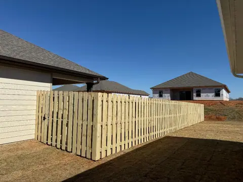 Wood shadowbox privacy fence running alongside a house