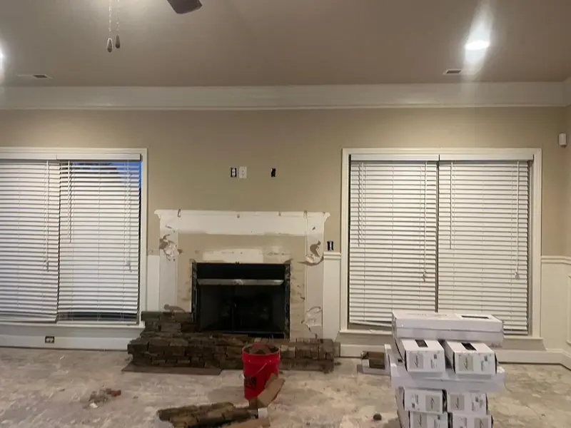 Living room fireplace wall before, with the old stone stripped down